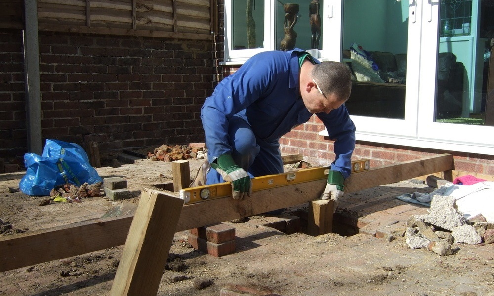 builder worker installing decking frame